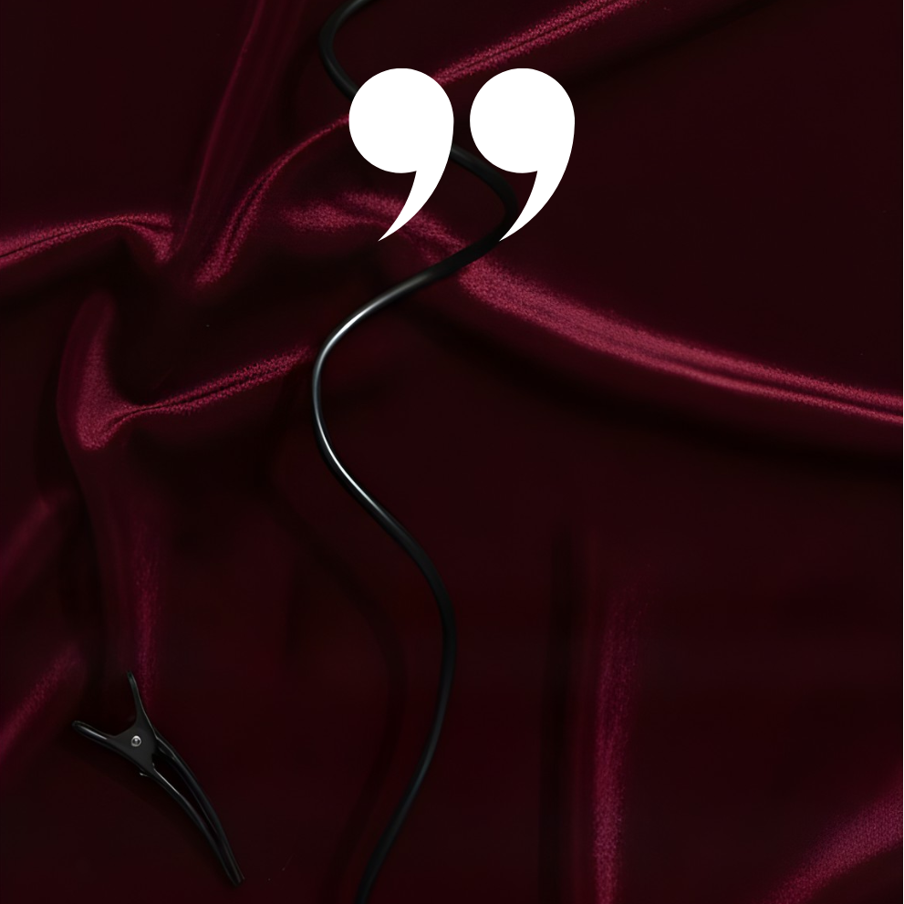 Quote marks on a dark red fabric background with a hair clip.